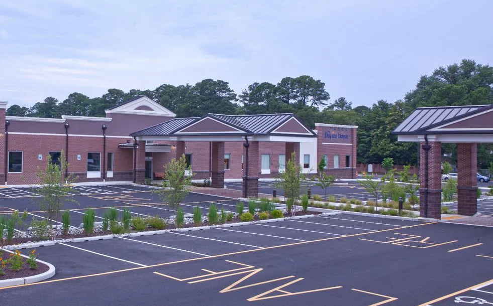 Brick commercial building with landscaped entrance and empty parking lot