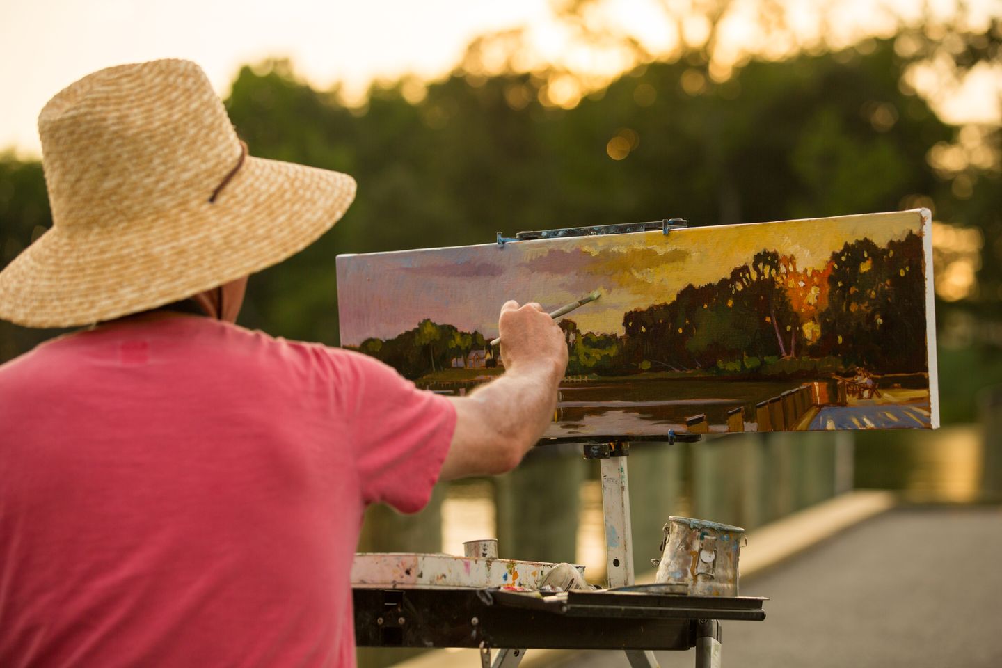 Man painting outside during sunset