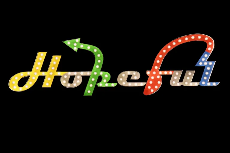 Sign: Hopeful spelled in colorful marquee bulbs with an arrow