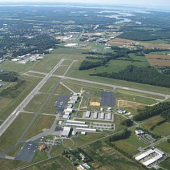 Aerial view of an airport with runways, hangars and farm fields