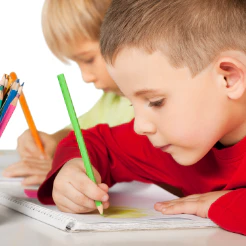 Two children coloring with colored pencils at a table