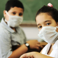 Two children wearing face masks in a classroom