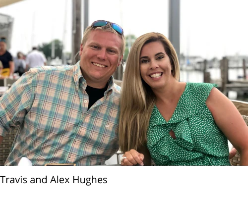 Travis and Alex Hughes smiling together at an outdoor waterfront table