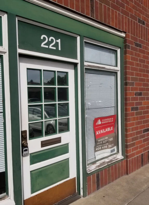 Storefront door numbered 221 with a red Available sign in the window