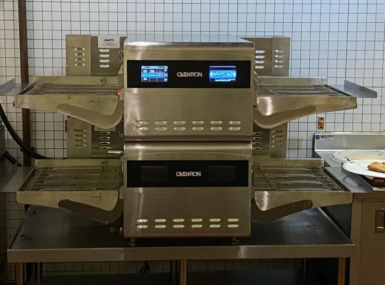 Stainless steel double-deck conveyor oven on a commercial kitchen counter