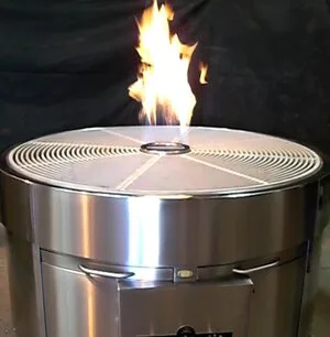 Round stainless steel fire pit with flames rising from its center grate
