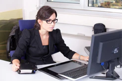 Woman with glasses working at a computer at a desk