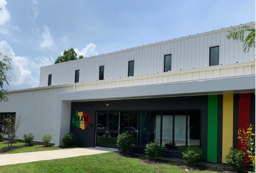 Exterior of a modern one-story building with red, yellow, and green accent stripes