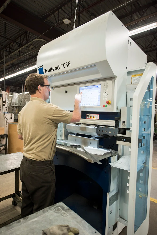 Man operating a TruBend 7036 machine at a factory