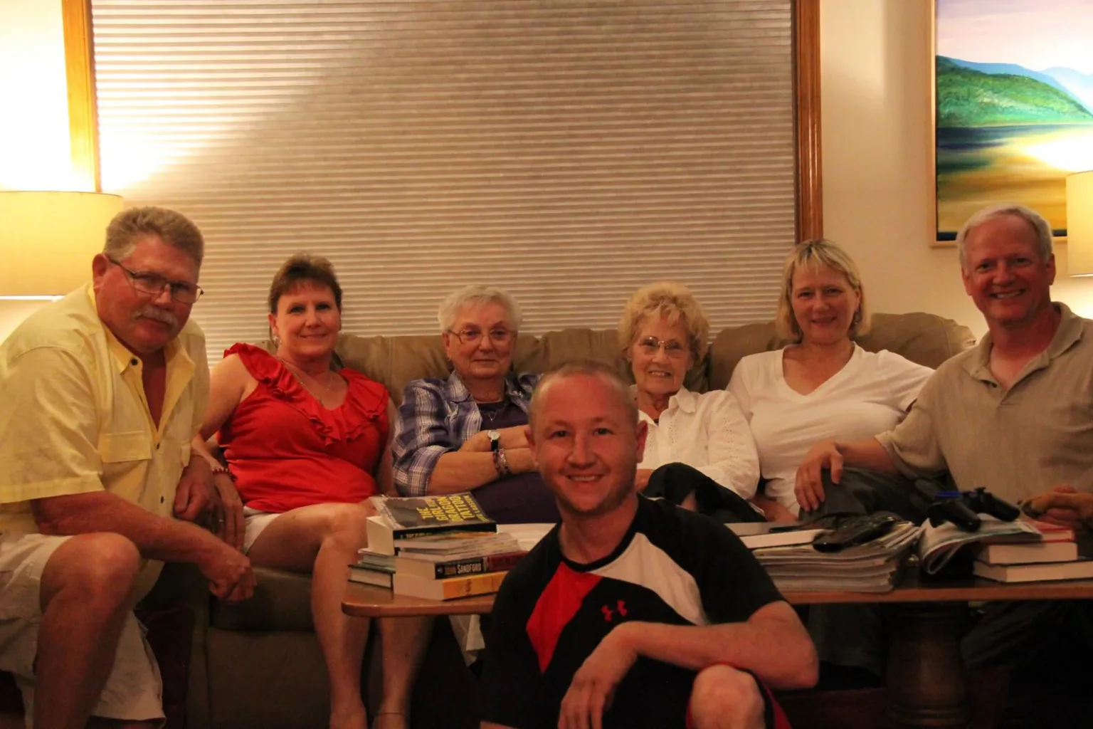 Six people relaxing together on a couch in a living room
