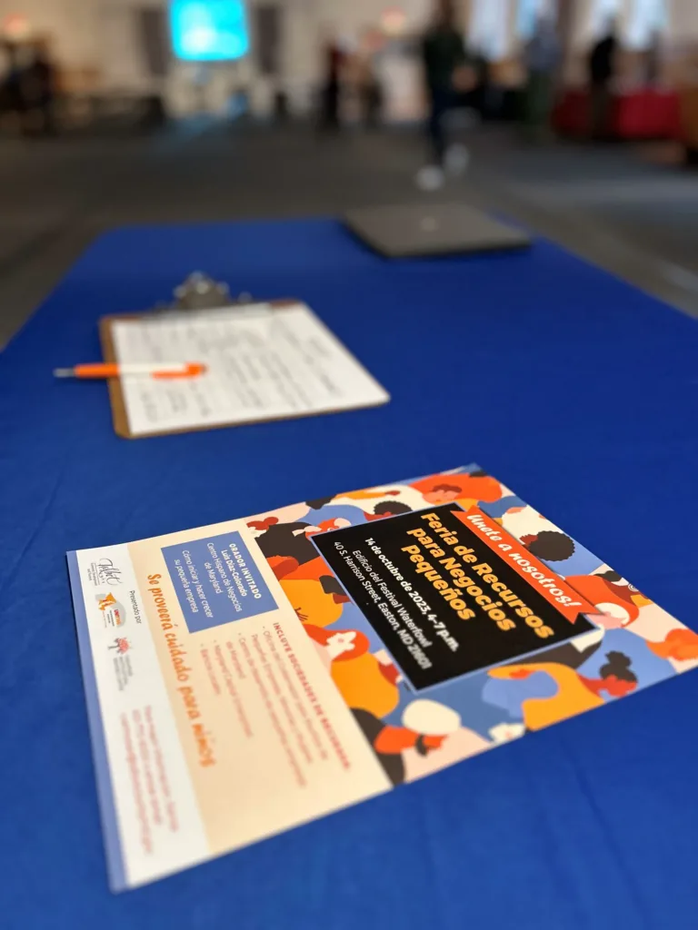Table with brochures and a flyer on a blue tablecloth at an event