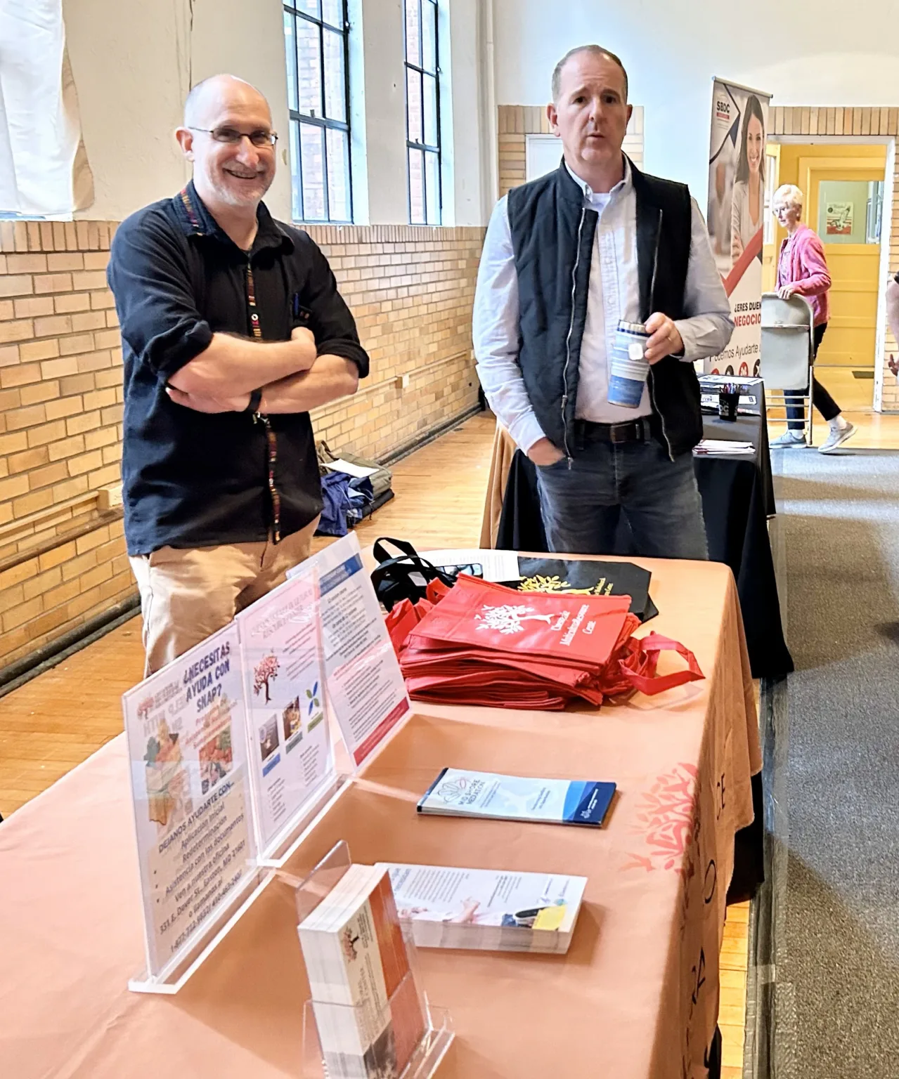 Two men standing beside an information table at a resource fair