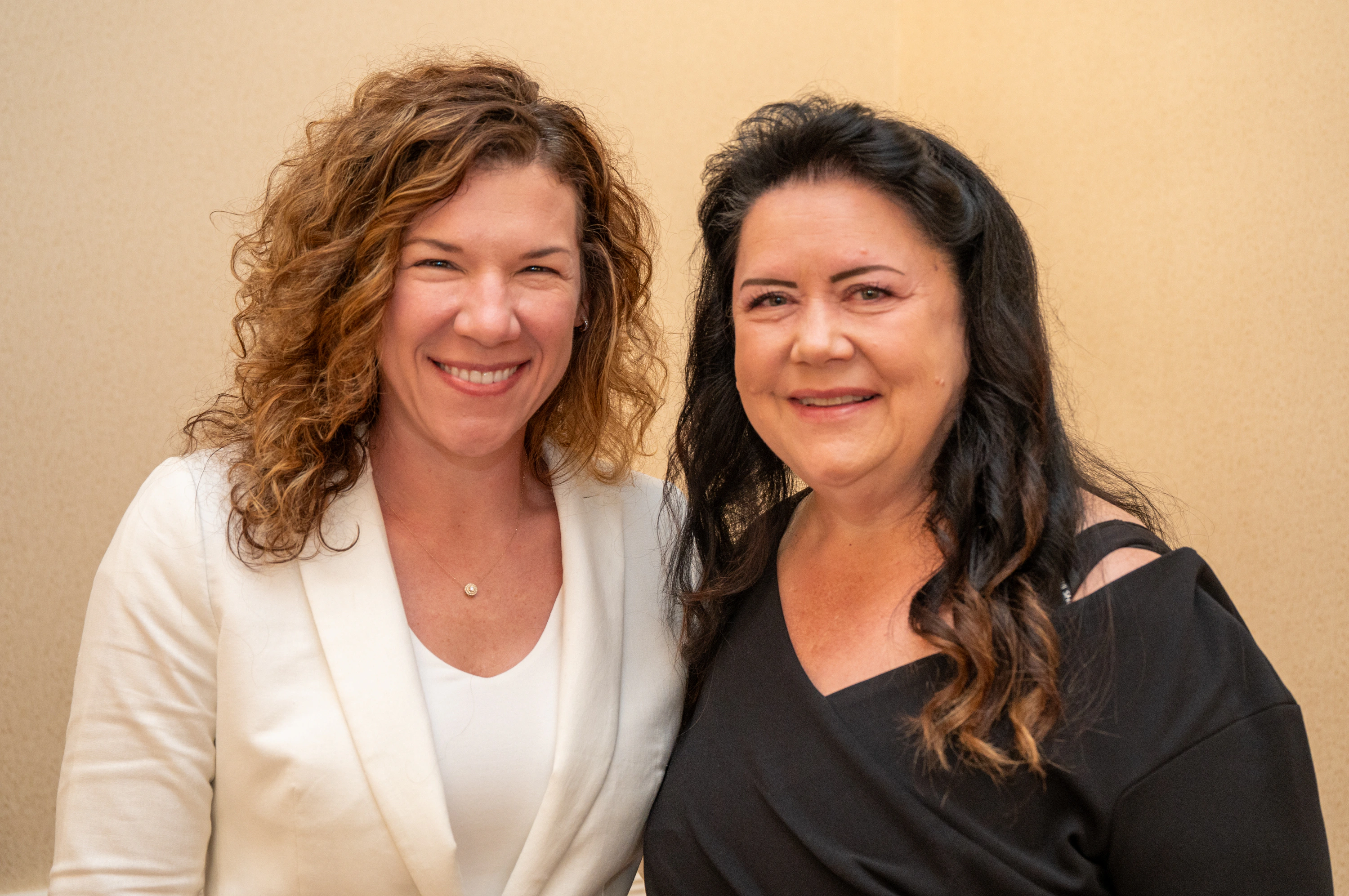 Two women smiling and posing together indoors