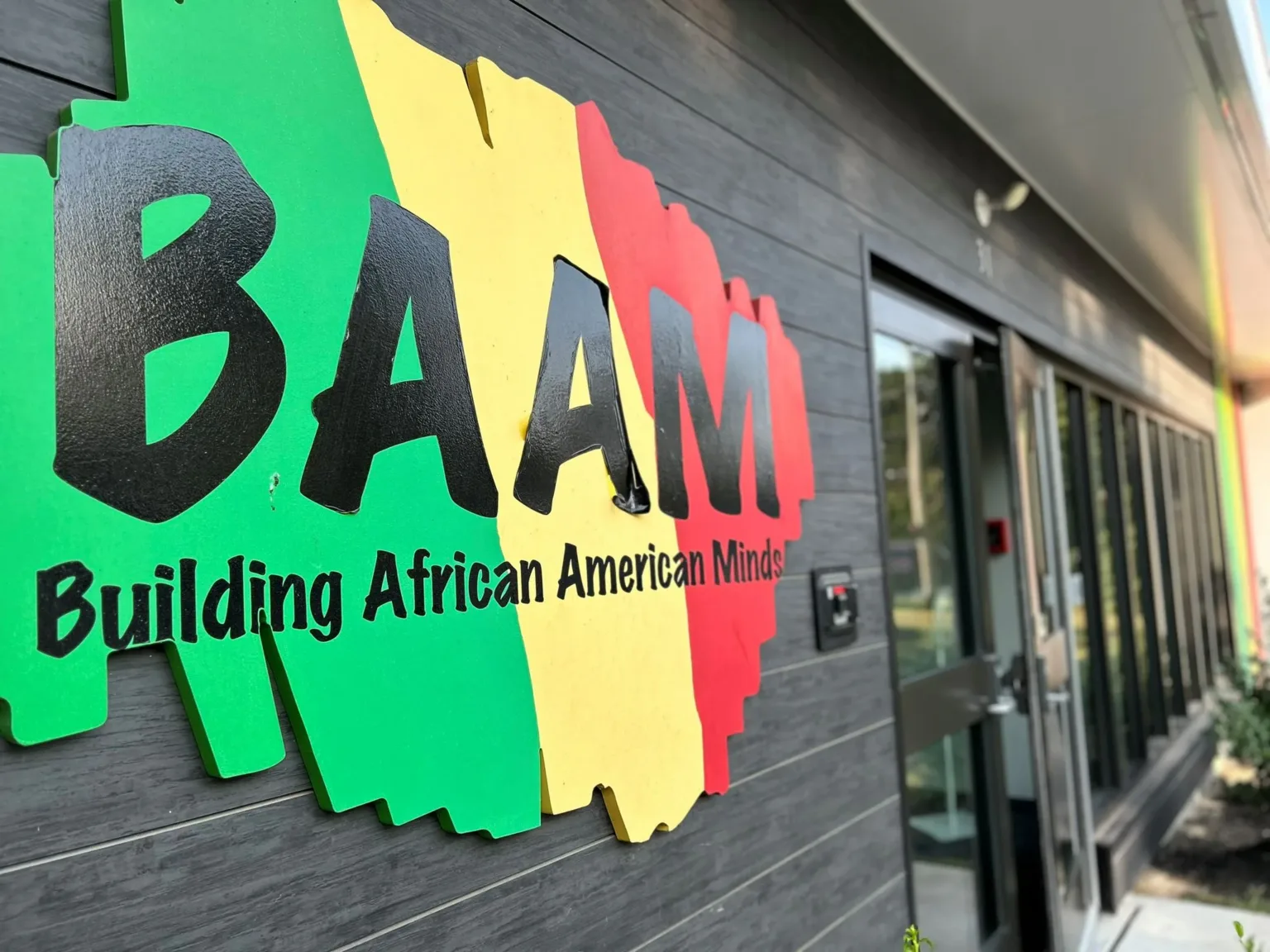 BAAM Building African American Minds sign in red, yellow, and green on a building wall
