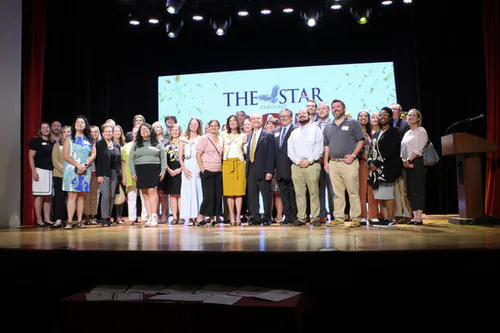 Group of people on stage in front of a THE STAR screen