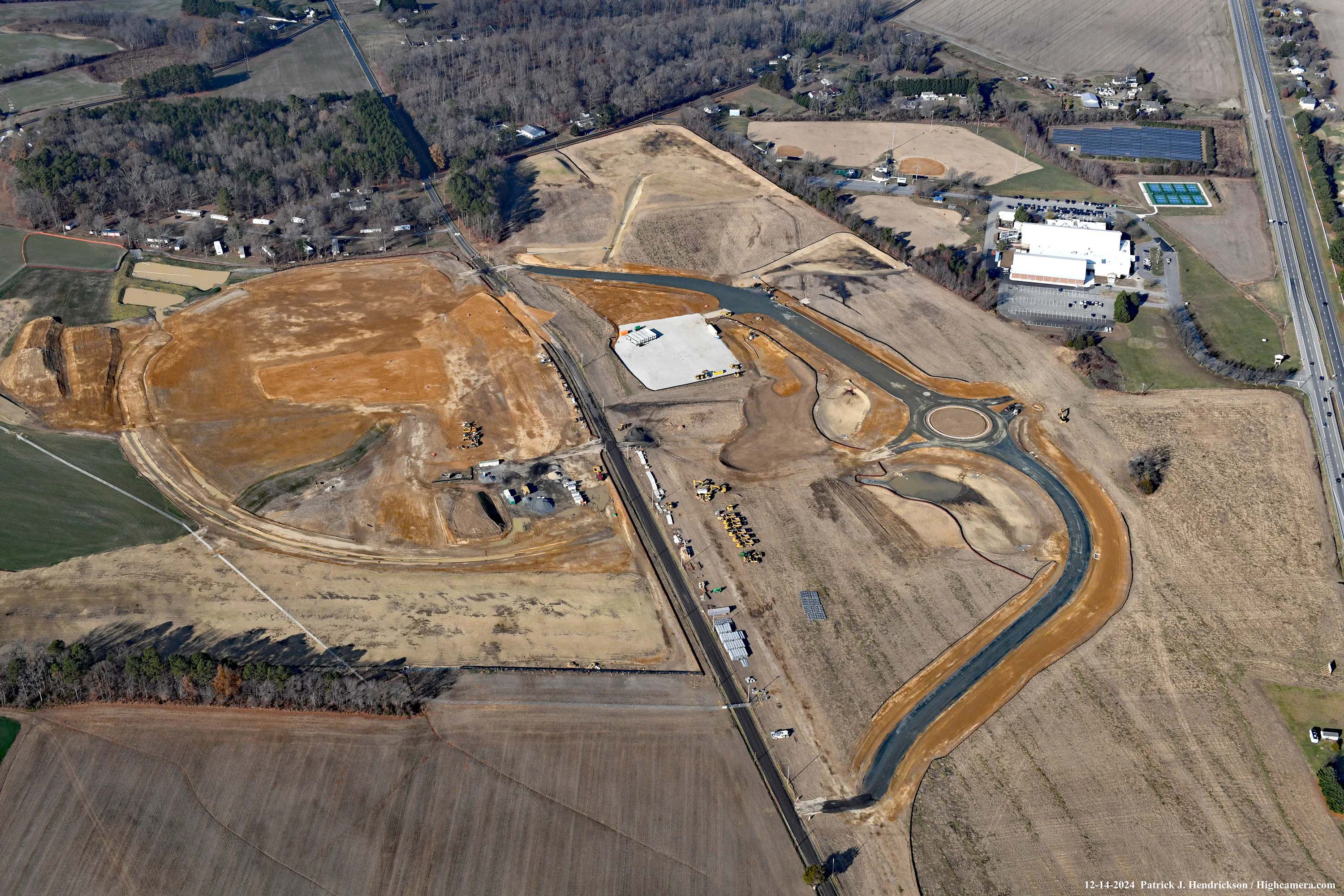 Aerial view of a large construction site with ponds and graded earth