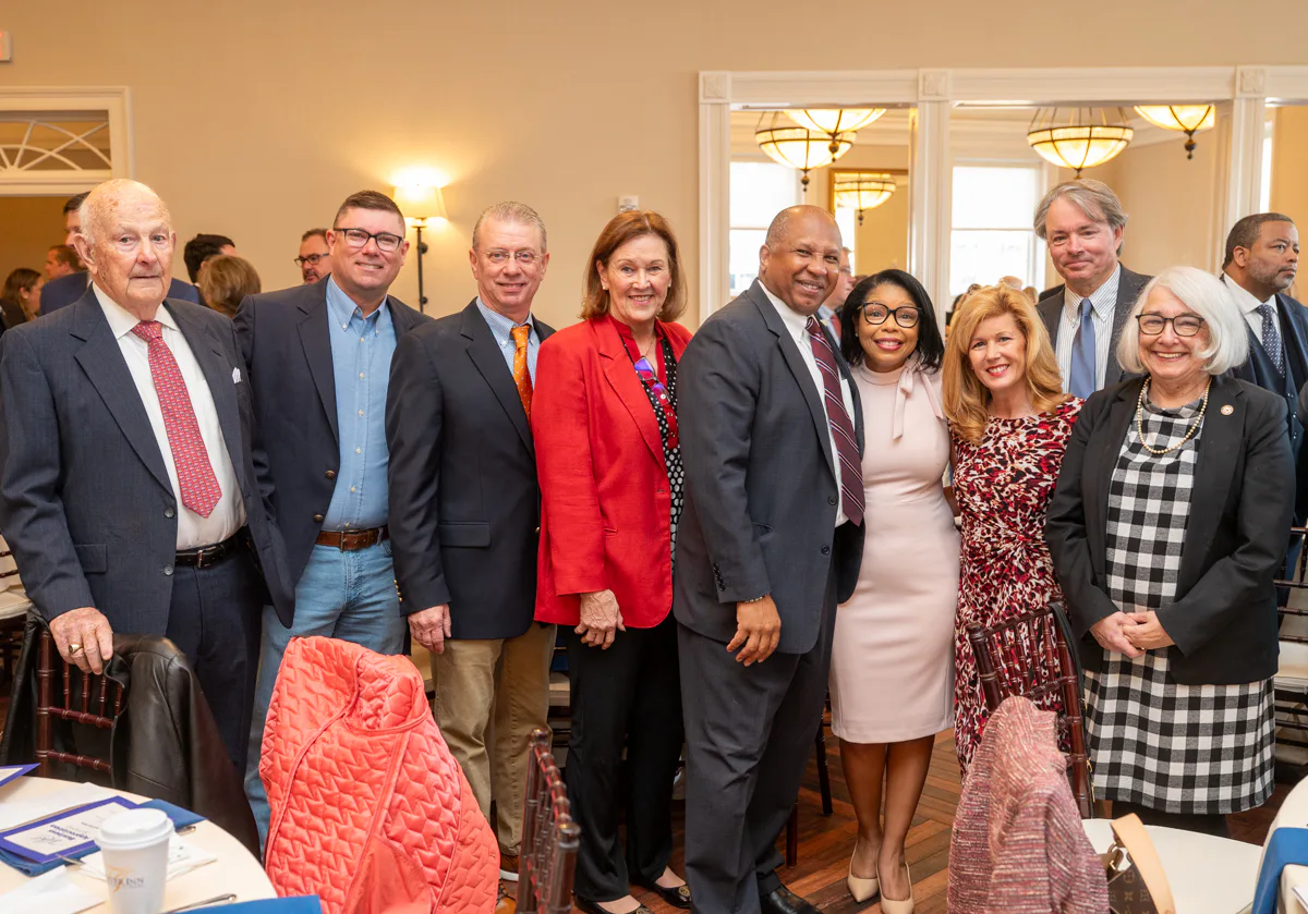 Group of about eight people pose together at a banquet event