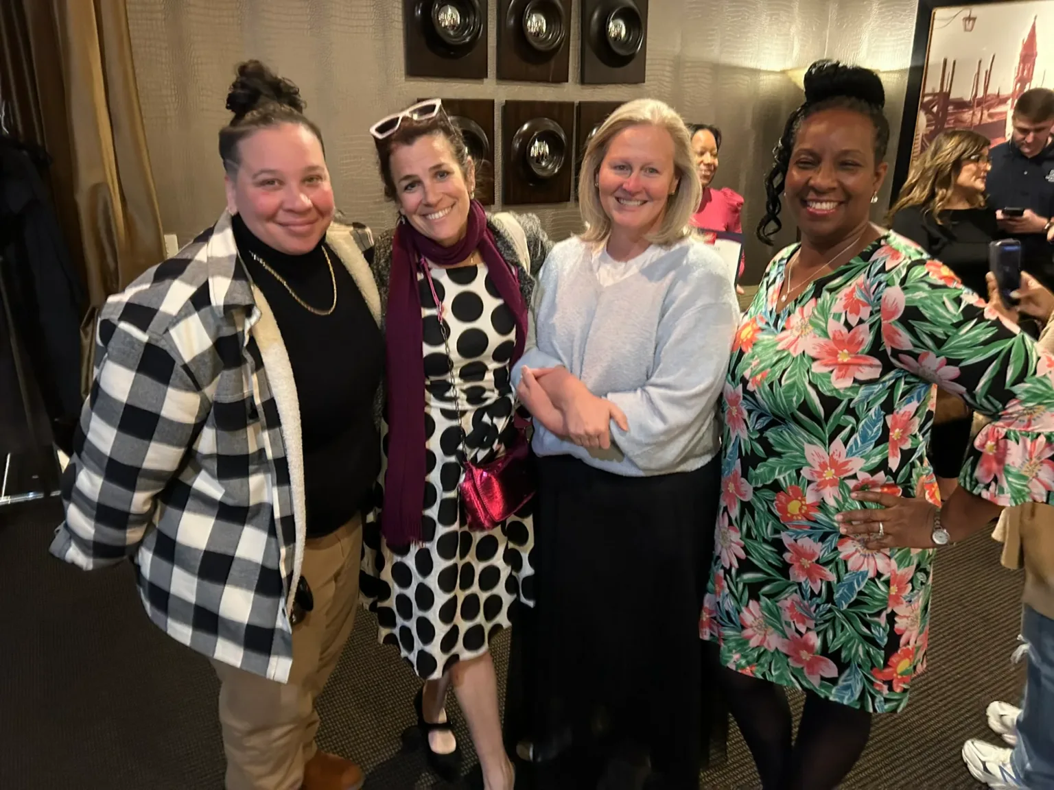 Five people posing together indoors at a reception