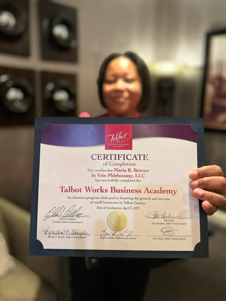 Smiling woman holding a Talbot Works Business Academy certificate