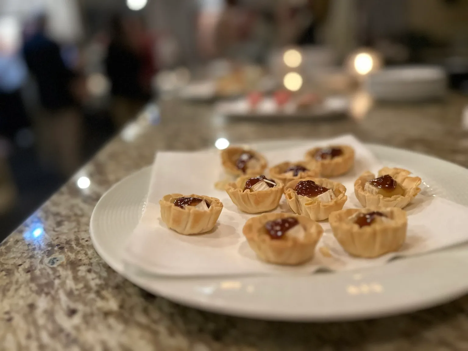 Mini tartlets topped with jam on a white plate