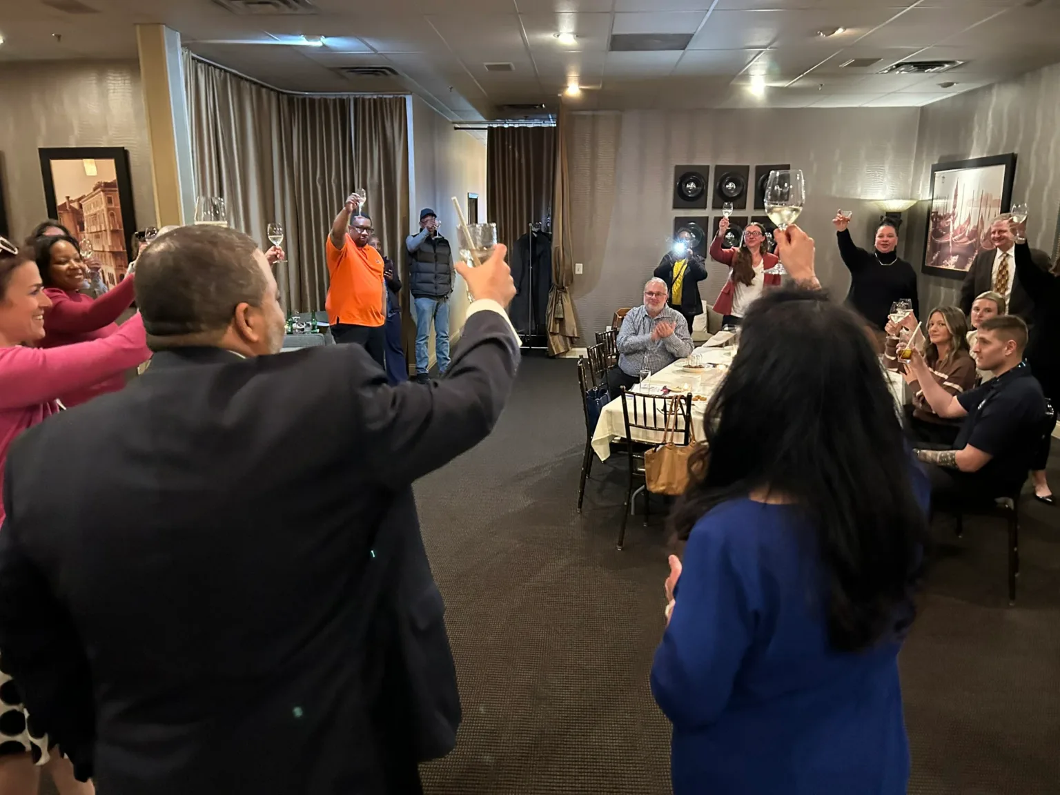 Guests raising their arms and cheering at a reception