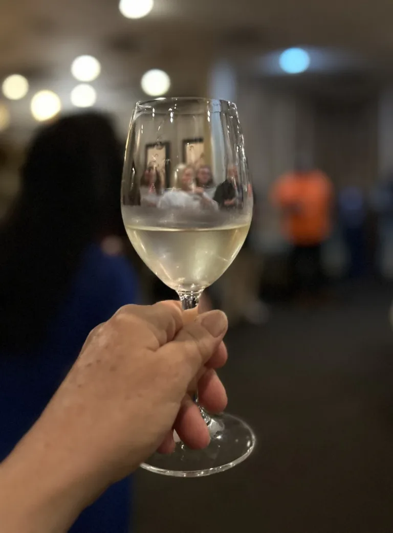 Close-up of a hand holding a glass of white wine