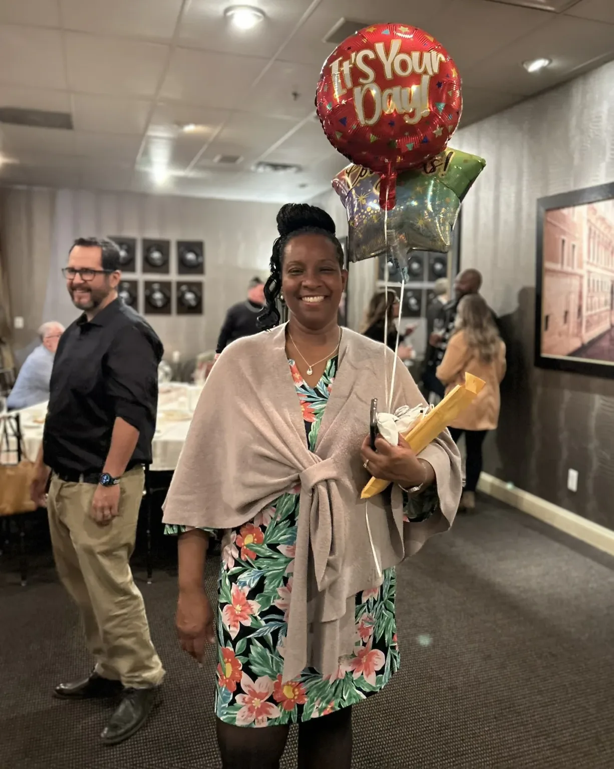 Smiling woman holding a balloon reading It's Your Day