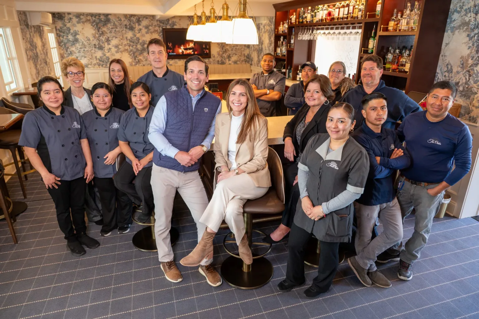 Group of restaurant staff posing together in a dining room