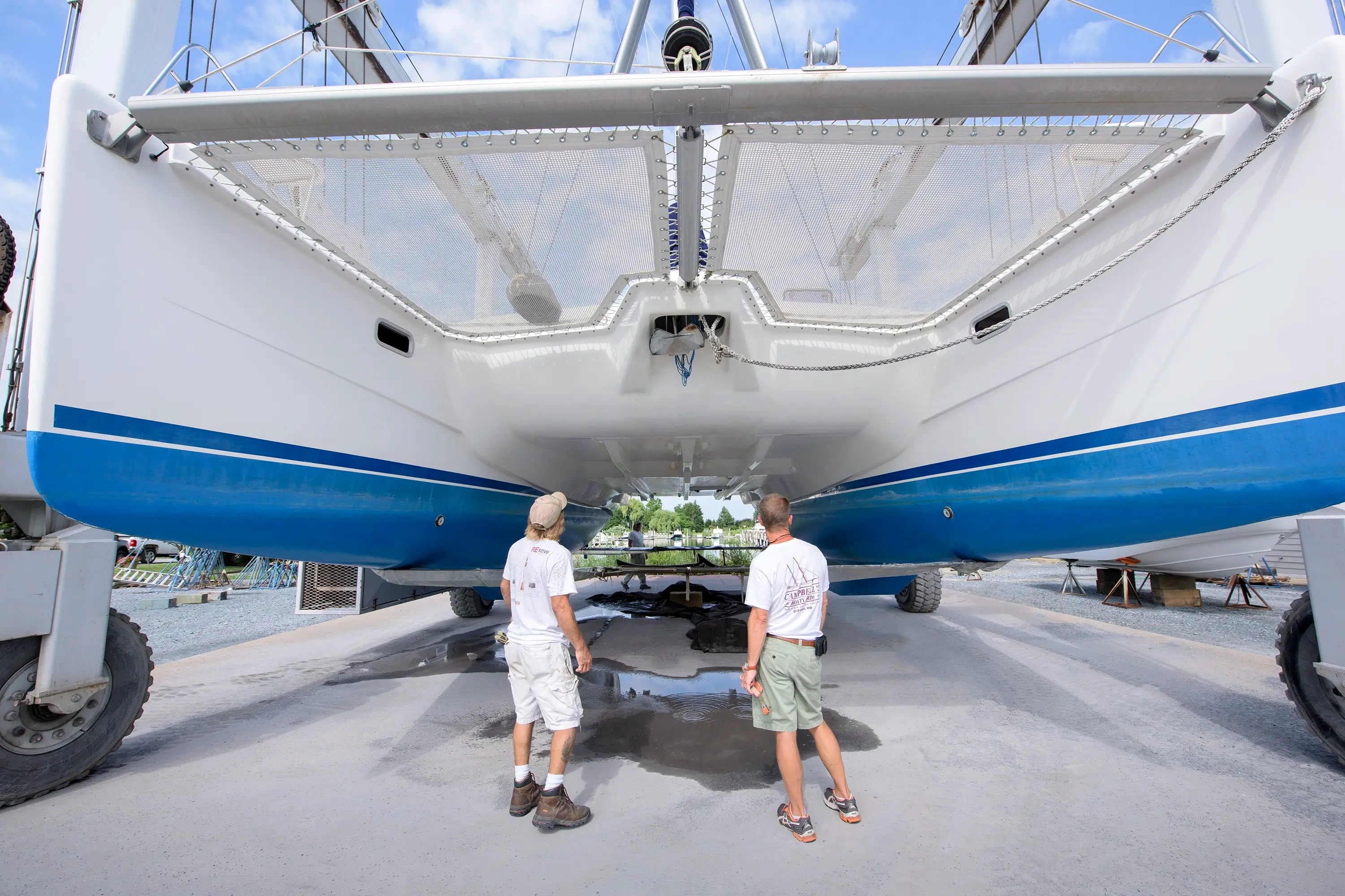 Two men looking at the underside of a boat