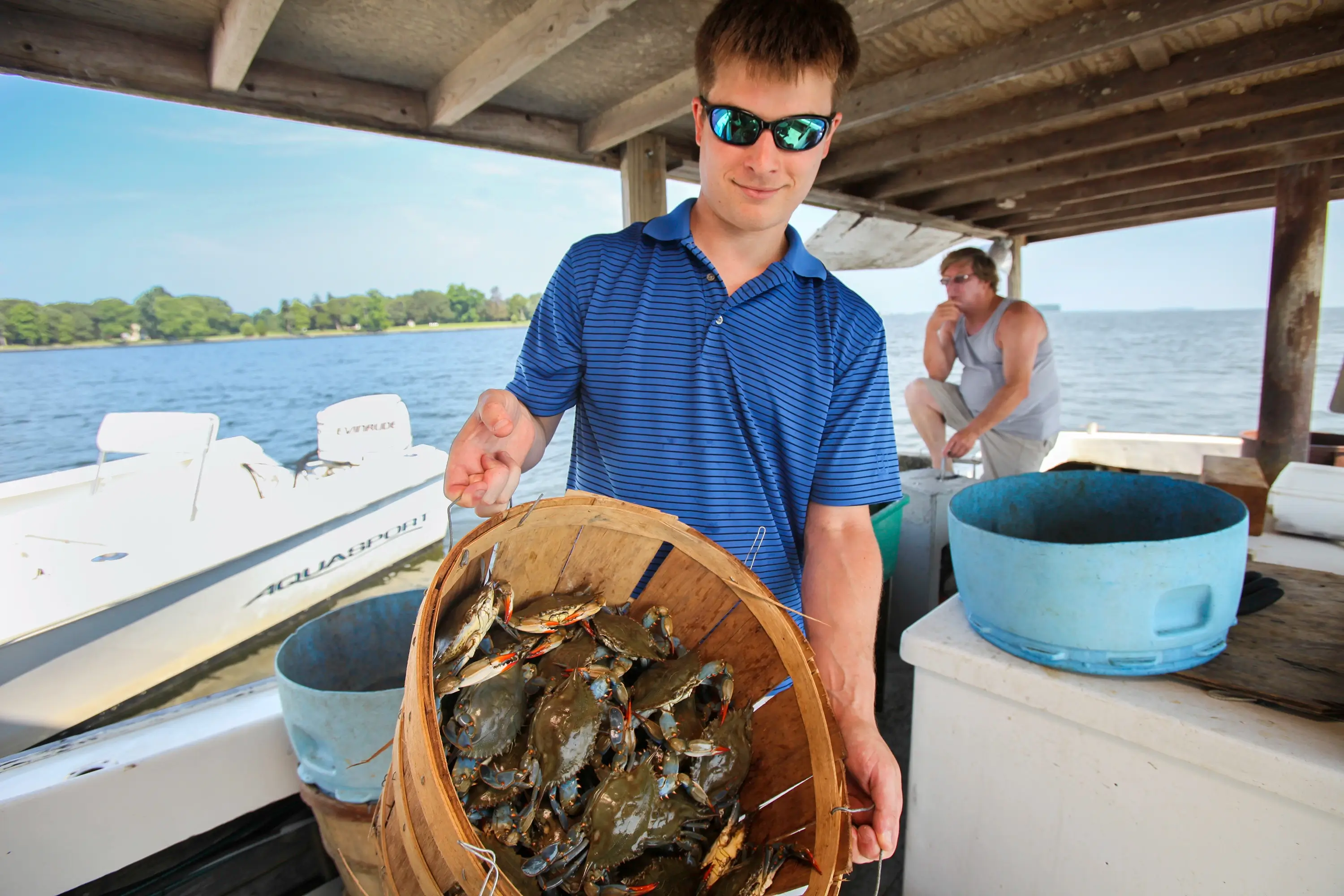 A man holding a basket full of crabs